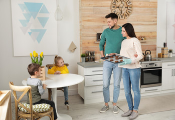 Canvas Print - Parents treating kids with oven baked cookies in kitchen