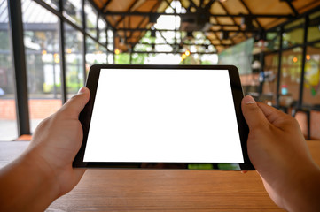 Poster - businessman hand working on tablet on wooden desk tablet with blank screen mockup Digital tablet computer