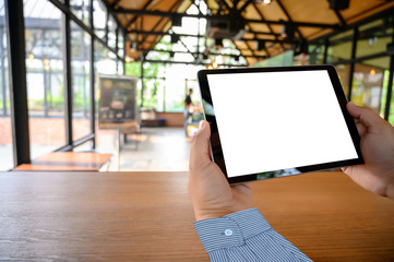Poster - businessman hand working on tablet on wooden desk tablet with blank screen mockup Digital tablet computer