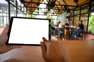 Poster - businessman hand working on tablet on wooden desk tablet with blank screen mockup Digital tablet computer