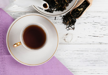 Teapot and cups on the wooden white table. Aromatic black tea. Concept of tea ceremony, break and having rest.