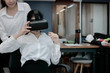 © tuaindeed - Cheerful Asian business woman wearing virtual reality glasses in office.