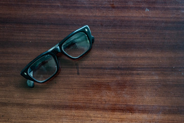 the old glasses on the brown wood table were a little dusty