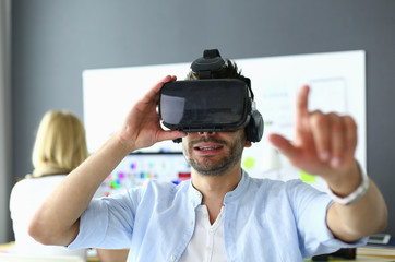 young male software programmer testing a new app with 3d virtual reality glasses in office.