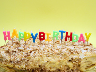 The inscription on the cake of candles, happy birthday. on a yellow background.