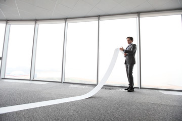 Businessman reading long paper list