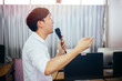 © twinsterphoto - Side view of male Asian businessman speaking and making a lecture in public speaking event in the room