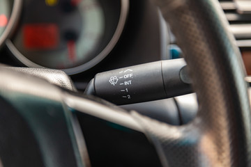 Canvas Print - The interior of the car with a view of the steering wheel, dashboard and windscreen wiper switch with light gray trim