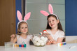 © erainbow - Girls paint easter eggs