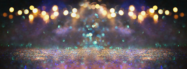 glitter vintage lights background. black, purple, blue and gold. de-focused