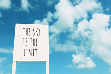 Wall Mural - sign against blue sky with clouds with the text – the sky is the limit