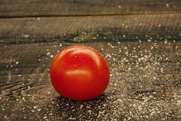 delicious cherry tomatoes sprinkled with salt on a wooden background