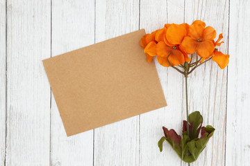 Wall Mural - Orange and red fall flowers with blank greeting card on weathered whitewash textured wood