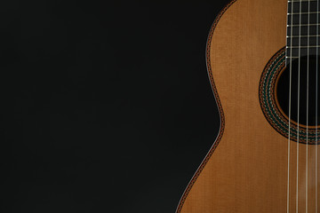 Beautiful six - string classic guitar against dark background, space for text