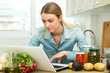 © JackF - Woman with laptop in kitchen