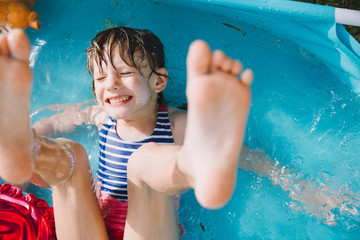adorable little girl having fun in children's swimming pool