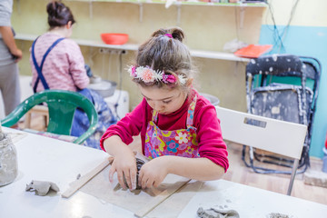 Wall Mural - Little Girl At Pottery Workshop Shaping Clay Vase