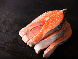 Raw salmon fish fillet on black background