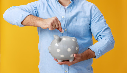  concept of Finance and business.  man with  piggy Bank on  yellow background color