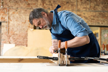 Wall Mural - Mature handsome joiner work in carpentry. He is successful entrepreneur at his workplace.