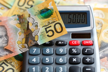 Wall Mural - Australian fifty dollar bill over a calculator. The new 2019 issue is designed to deter counterfeiting, the note is polymer and water resistant with a clear holographic strip