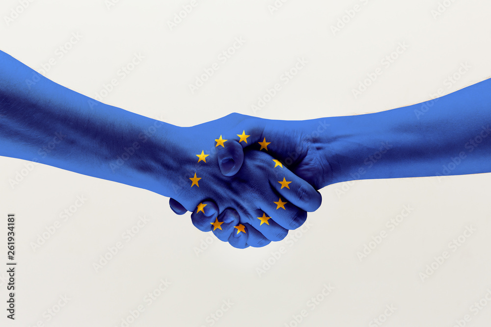 Cooperation agreement. Male hands shaking colored in blue EU flag isolated on gray studio background. Concept of help, commonwealth, unity of European countries, political and economical relations. - obrazy, fototapety, plakaty 