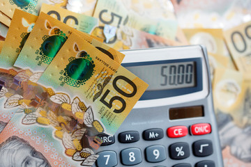 Wall Mural - Australian fifty dollar bill over a calculator. The new 2019 issue is designed to deter counterfeiting, the note is polymer and water resistant with a clear holographic strip