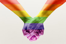 Right To Choose Your Own Way. Loseup Shot Of A Gay Couple Holding Hands, Patterned As The Rainbow Flag Isolated On White Studio Background. Concept Of LGBT, Activism, Community And Freedom.