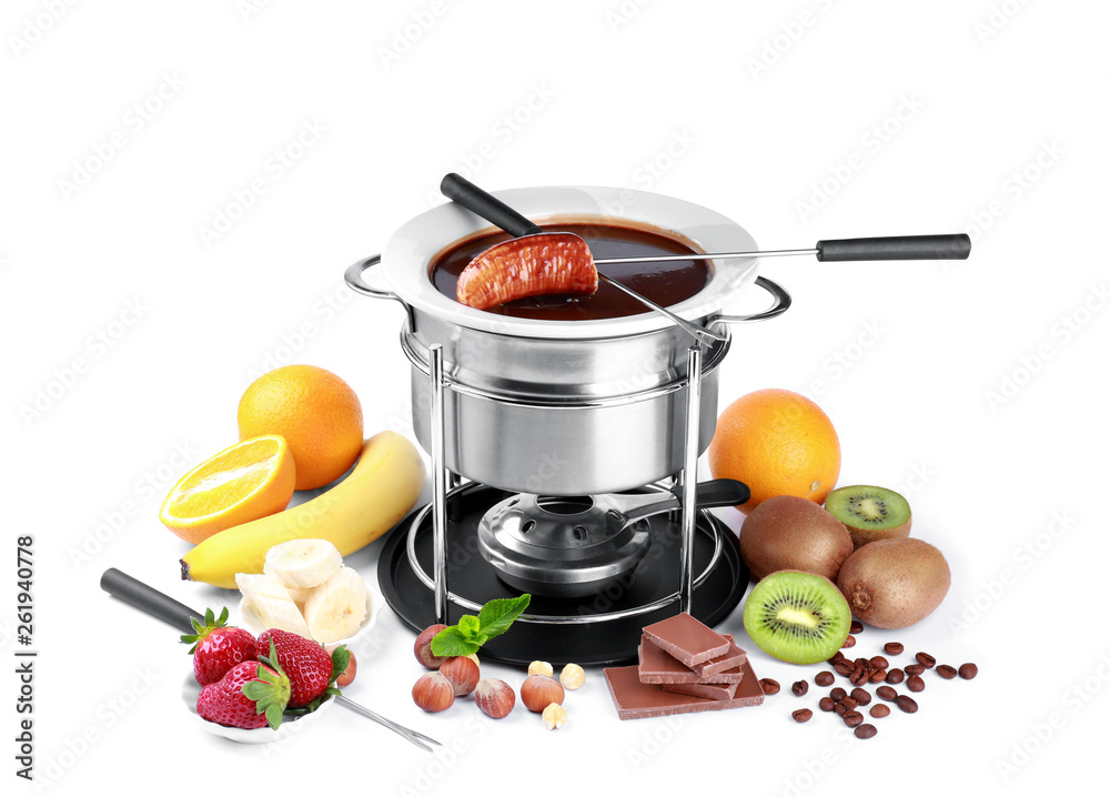 Fondue pot with melted chocolate and fruits on white background