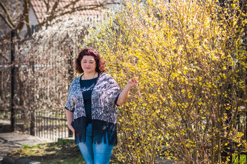 Beautiful woman wearing knitted cardigan, jeans at nature. Casual fashion, elegant everyday look. Plus size model 