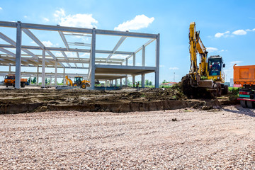 backhoe is loading a truck with ground on building site