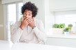 © Krakenimages.com - African American man at home shocked covering mouth with hands for mistake. Secret concept.