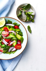 Wall Mural - Mixed salad made with cherry tomatoes, arugula, red onion, avocado and mint leaves. Healthy home made food. Flat lay. Copy space