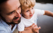 © Halfpoint - A close-up of father with a toddler boy outdoors by the river in summer.