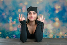 I'll Tell You Everything. Studio Photo Portrait Of A Cute Young Caucasian Brunette Girl In A Headscarf And Black Dress Looking Straight Into The Camera On A Colored Background Talking.
