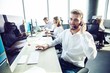 © opolja - Happy young male customer support executive working in office.