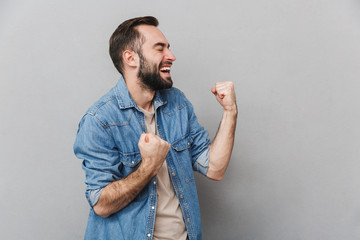 Wall Mural - Excited cheerful man wearing shirt standing isolated