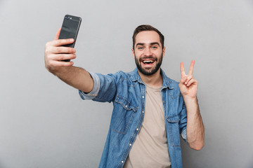 Wall Mural - Excited cheerful man wearing shirt standing isolated