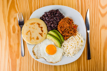 Poster - Venezuelan breakfast of arepa, fried egg, black beans, mechada meat, white cheese and avocado