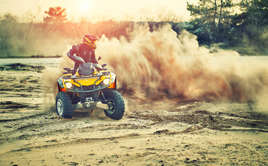 Wall Mural - Teen riding ATV in sand dunes making a turn in the sand