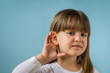© Marija - Little girl with hearing problem on light blue background. Close up, copy space.