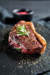 Wall Mural - beef ramp steak with rosemary. black background, top view.