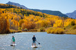 © Tandem Stock - A woman and man enjoy the fall bliss while paddle boarding on an inflatable SUP boards near Telluride, Colorado in autumn in the San Juan Mountains.
