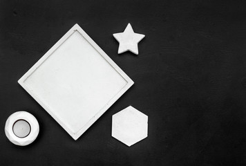 modern design of work desk with candle, star figures on black background top view copy space