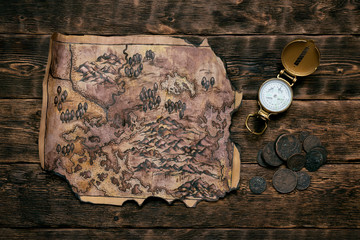 Wall Mural - Old map and compass on a adventurer table background. Treasure hunt concept.