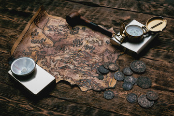 Wall Mural - Old map, water flask, flashlight and coins on a adventurer table background. Treasure hunt concept.