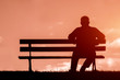 © goami - old man sitting alone on park bench under tree;