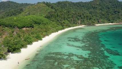 Wall Mural - Aerial drone view flying along a tropical island with sandy beach and traditional wooden boats (Swinton Island, Myanmar)