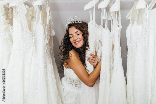 Fotomural Beautiful young brunette woman choosing wedding dress in a bridal salon