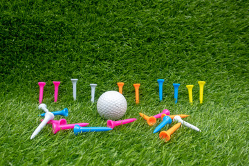 Golf ball with colourful tees are on green grass